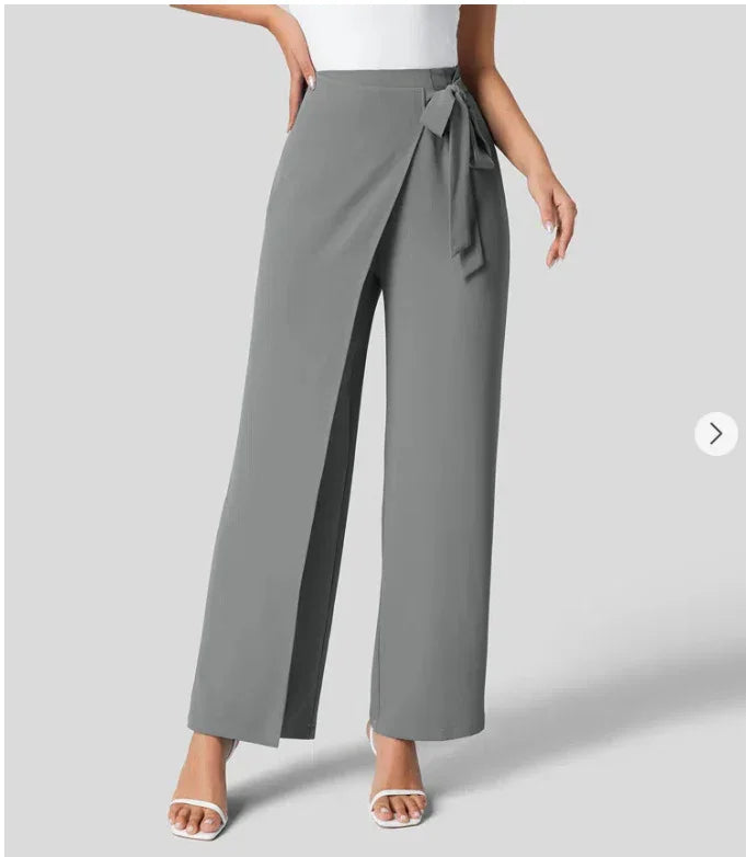 Women's high-waist wide-leg gray pants with tie waist detail, paired with white sleeveless top and white heels