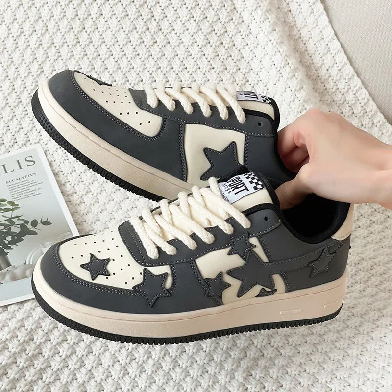 Black and white star-patterned casual sneakers with white laces on a textured fabric background