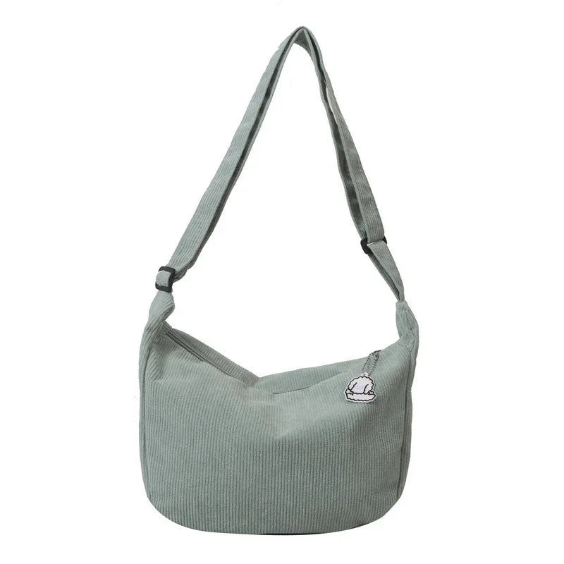 Light green corduroy shoulder bag with adjustable strap and small white cloud charm