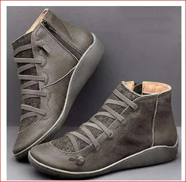 Gray high-top leather casual shoes with side zipper and flat rubber soles on gray background