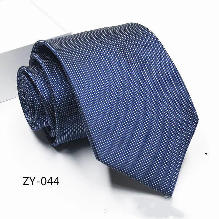 Blue patterned men's necktie with fine dot design, rolled and displayed on white background