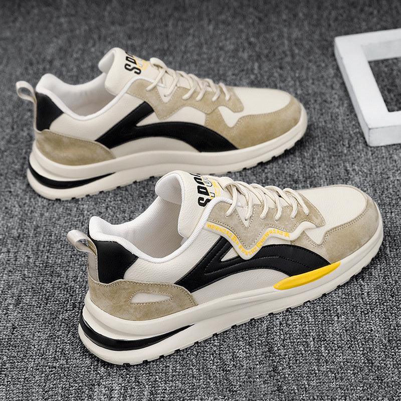Light beige and black casual sneakers with yellow accents on grey carpet background
