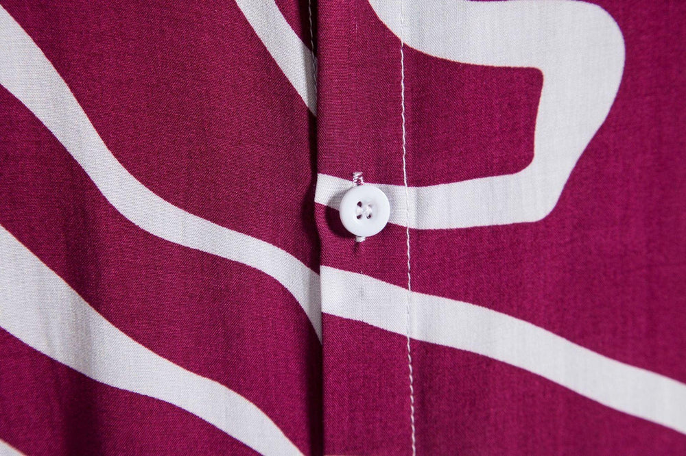 Close-up of white button on purple fabric with white abstract wavy stripes pattern
