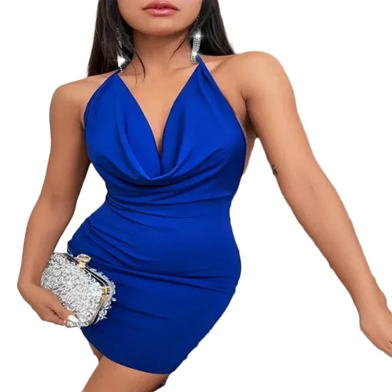 Woman wearing a royal blue halter neck mini dress holding a silver embellished clutch, with long straight hair and sparkling earrings