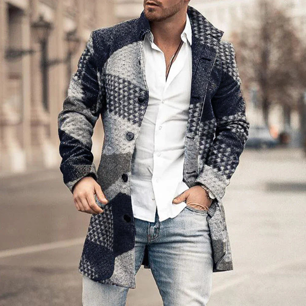 Man wearing a stylish blue and gray checkered long coat over a white shirt and light blue jeans on city street