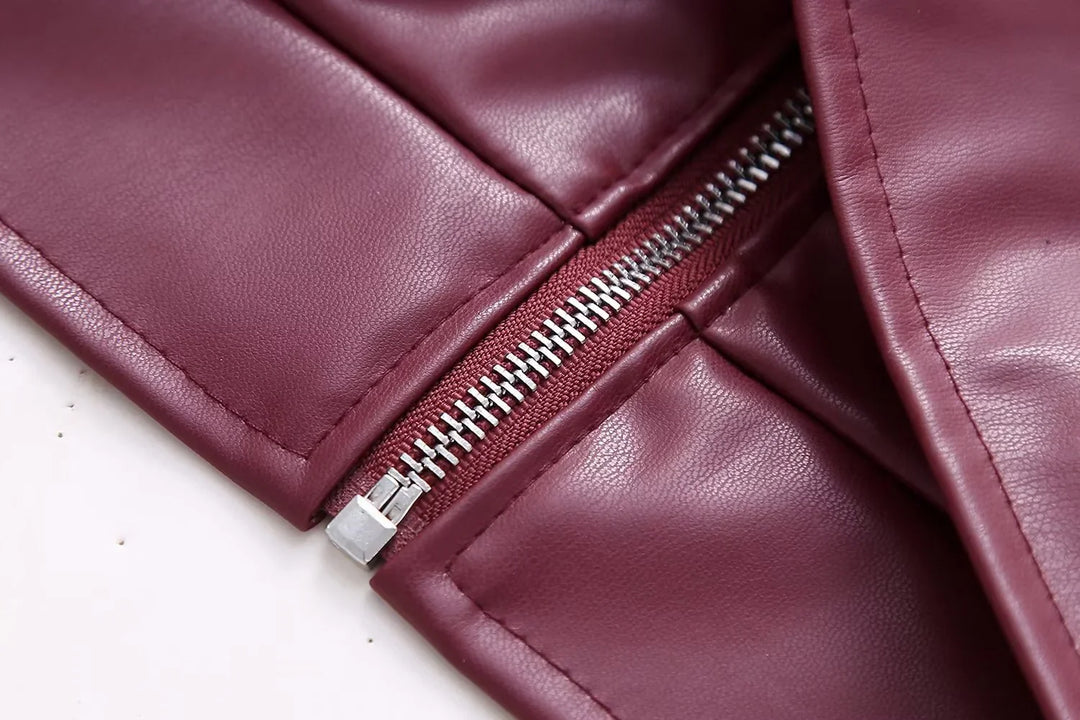 Close-up of burgundy leather garment with silver zipper detail