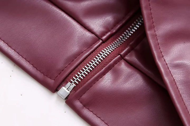 Close-up of burgundy leather garment with silver zipper detail