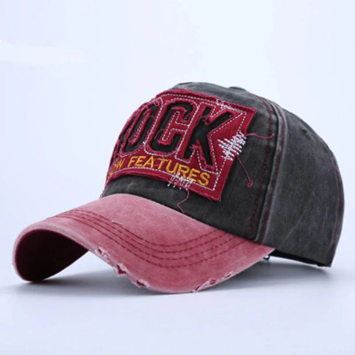 Vintage style baseball cap with distressed pink brim and black crown featuring embroidered red patch reading 'ROCK NEW FEATURES'