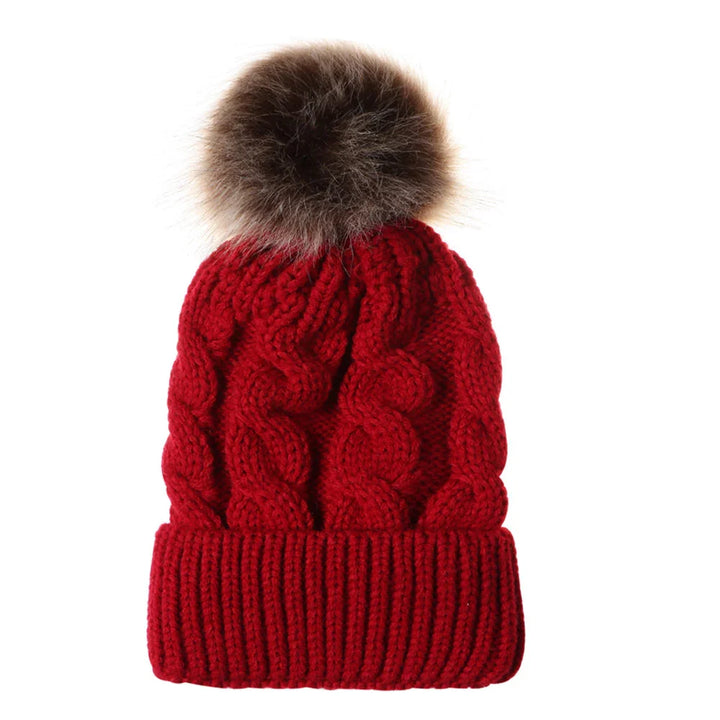 Red knitted winter beanie hat with cable pattern and brown faux fur pom-pom