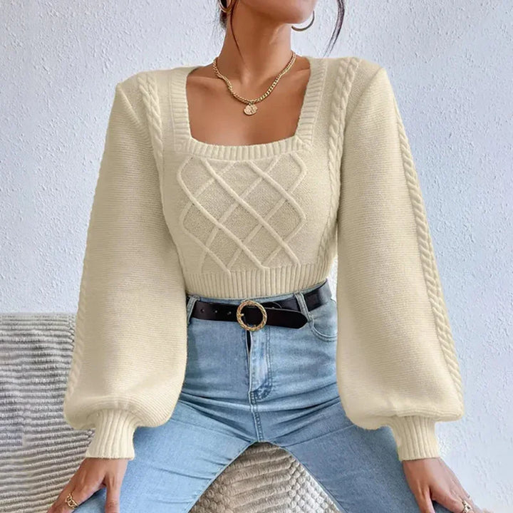 Woman wearing cream cable knit sweater with balloon sleeves and square neckline paired with high-waist jeans