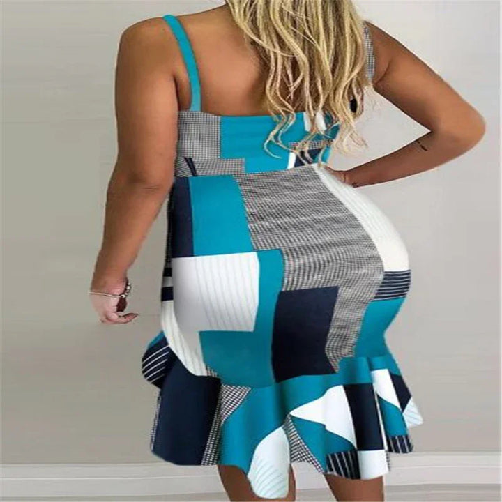 Woman wearing a sleeveless, blue, white, and black patchwork pattern bodycon dress with flounce hem