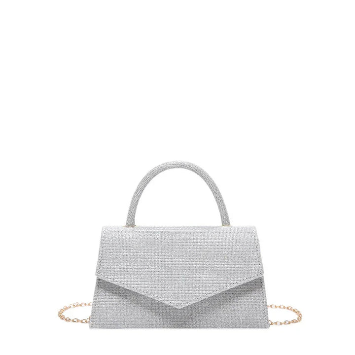 Silver glitter handbag with top handle and gold chain strap on white background