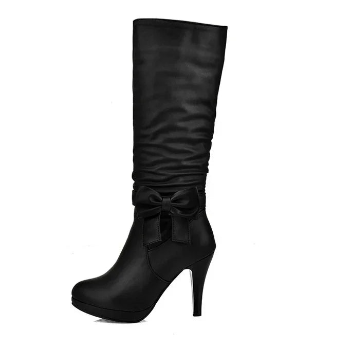 Black high-heeled women’s boot with ruched shaft and decorative bow on side