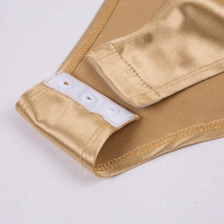 Close-up of gold satin strap with white snap fasteners on beige fabric