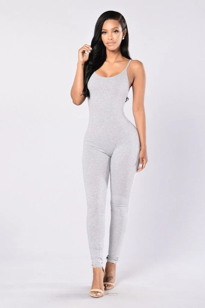 Woman in light gray sleeveless fitted jumpsuit posing on white background