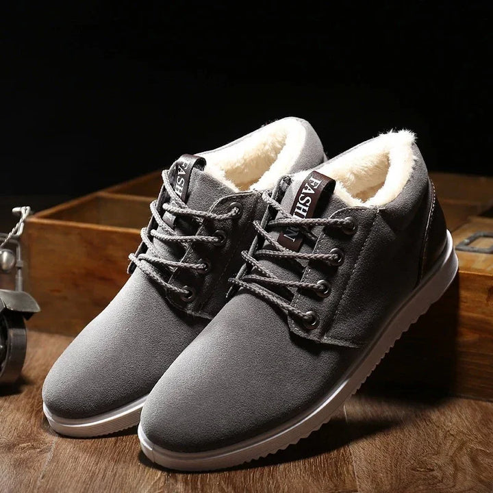 Gray casual winter shoes with fleece lining and white soles on wooden surface