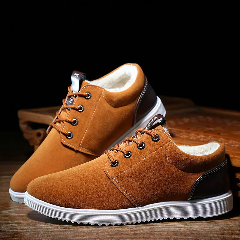 Brown suede casual sneakers with white rubber soles and plush inner lining on wooden surface