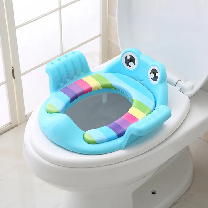 Blue frog-shaped toddler potty training seat with rainbow stripes on a white toilet