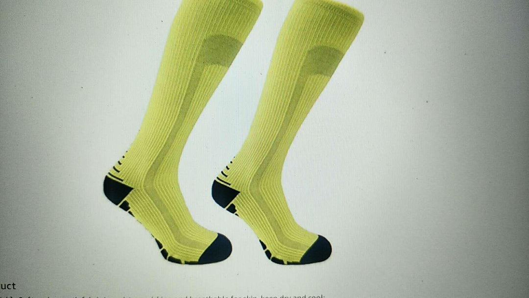 Pair of yellow knee-high sports socks with black heels and toes on white background
