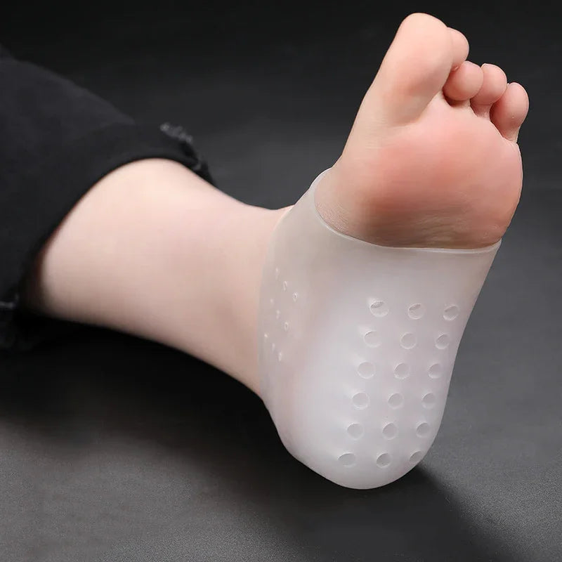Foot wearing a transparent silicone gel heel protector with cushioning dots on a black background