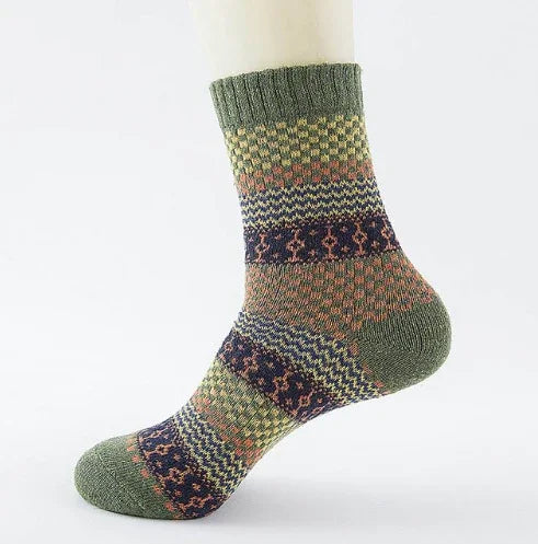Green wool sock with colorful geometric patterns displayed on a white mannequin foot