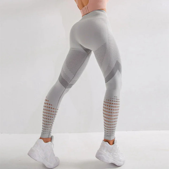 Woman wearing light gray seamless textured leggings and white sneakers against white background