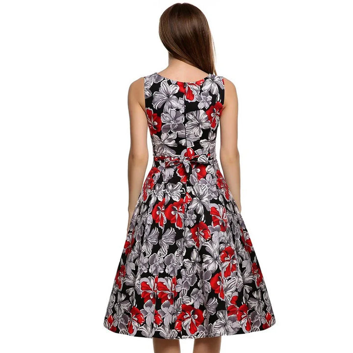 Woman wearing sleeveless black dress with red and white floral print, back view
