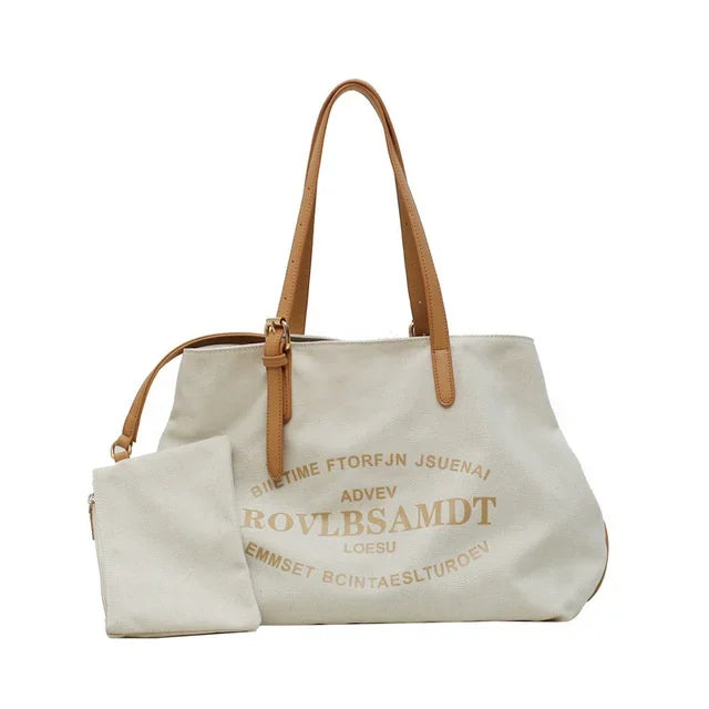 Beige canvas tote bag with brown leather handles and matching pouch featuring printed text design