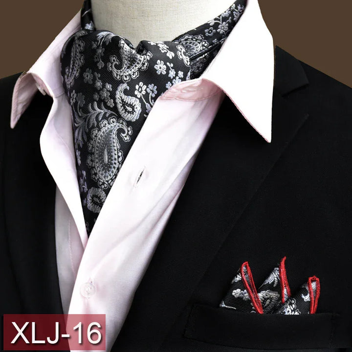 Black paisley silk ascot scarf with red-trimmed pocket square on black suit and light pink dress shirt