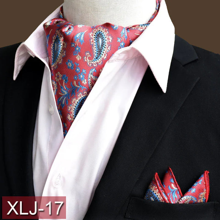 Red paisley ascot tie and matching pocket square on white shirt and black suit jacket