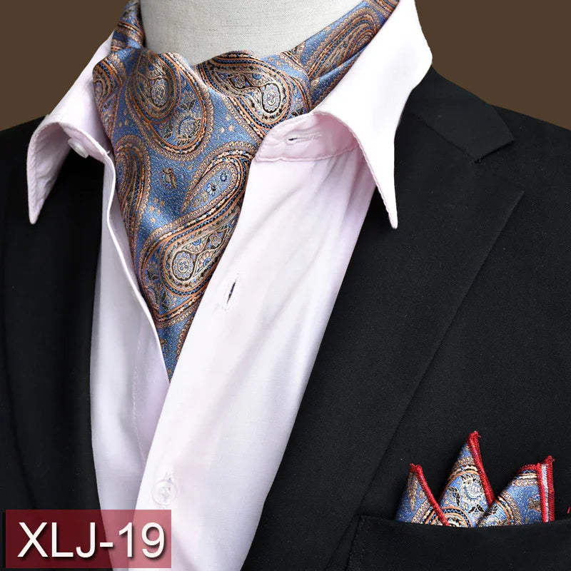 Blue and gold paisley ascot scarf with matching pocket square on black suit and white shirt