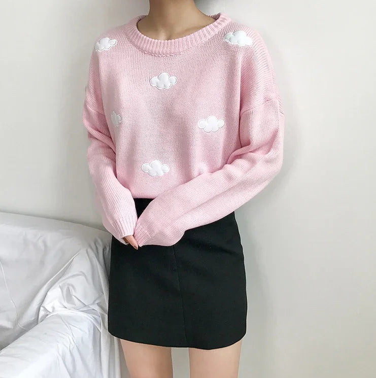 Woman wearing pink sweater with white cloud patterns and black mini skirt indoors