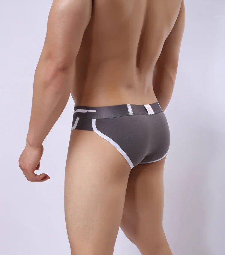 Rear view of a man wearing gray men's briefs with white trim on a light background