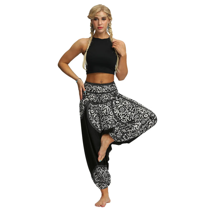 Woman in black crop top and patterned black and white harem pants posing for yoga or dance