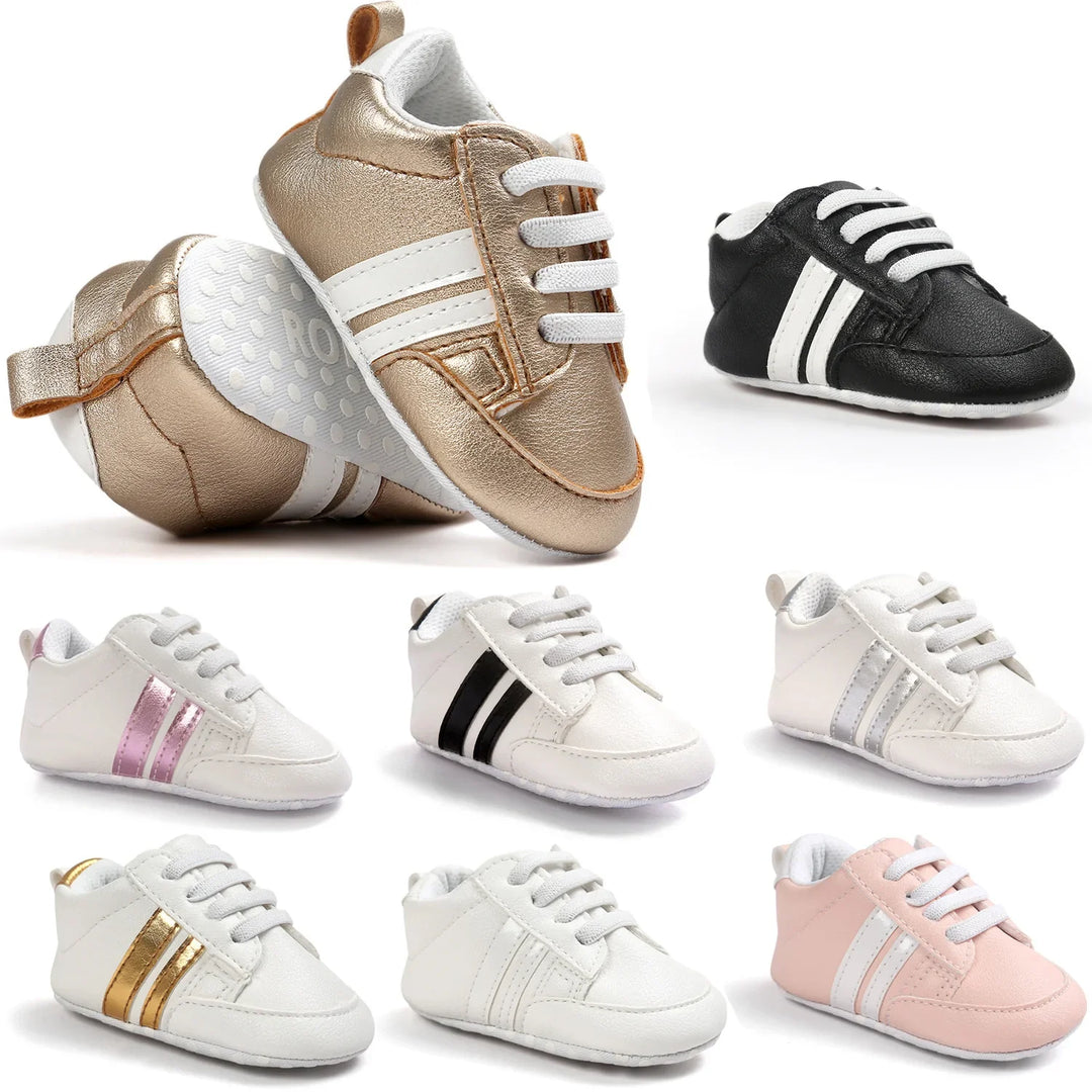 Assorted baby soft leather sneakers in gold, black, white, pink, and metallic stripes on white background