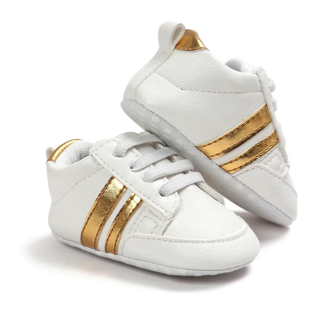 White baby sneakers with gold stripes and laces, soft sole and padded ankle collar