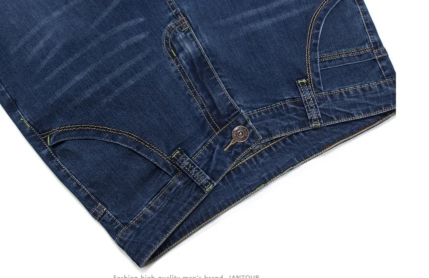 Close-up of dark blue denim jeans with contrast stitching and metal button closure