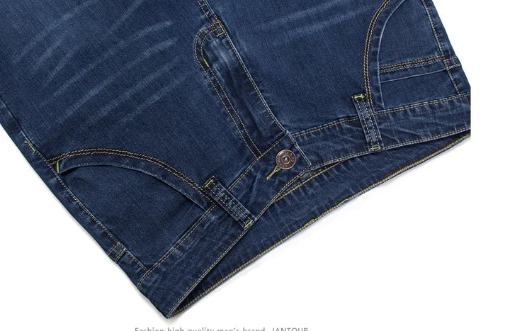 Close-up of dark blue denim jeans with contrast stitching and metal button closure