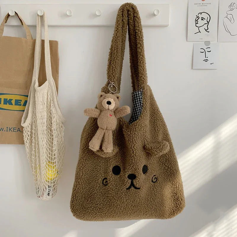 brown teddy bear face plush tote bag with small teddy keychain hanging on white wall hooks