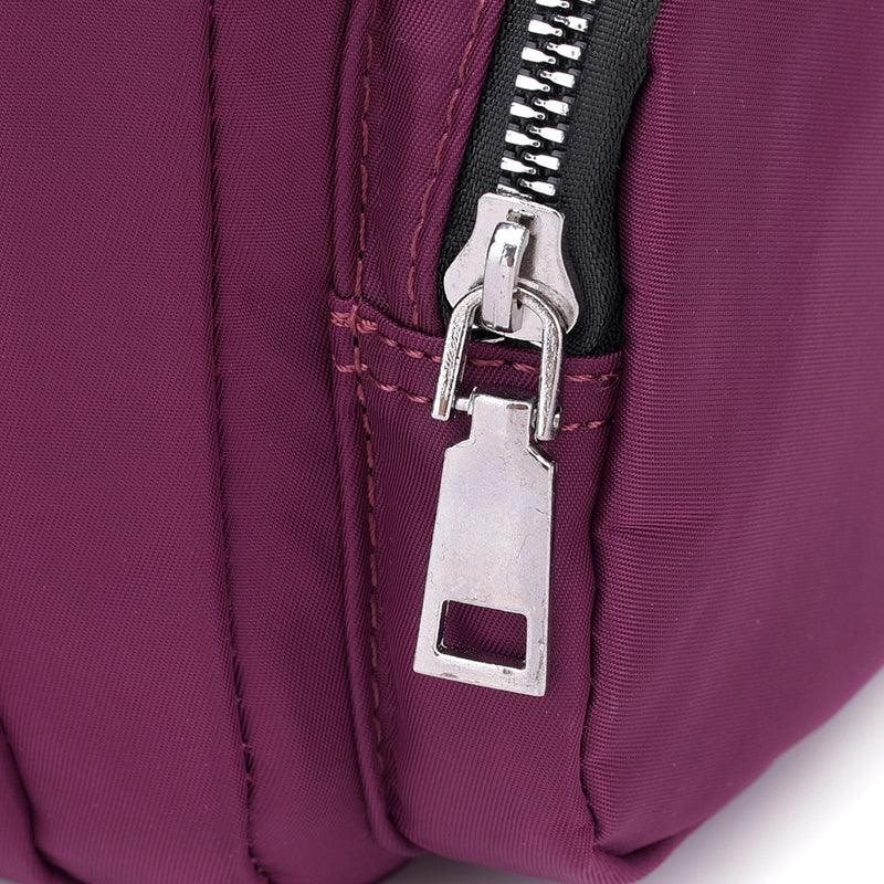 Close-up of silver zipper on purple fabric bag with detailed stitching