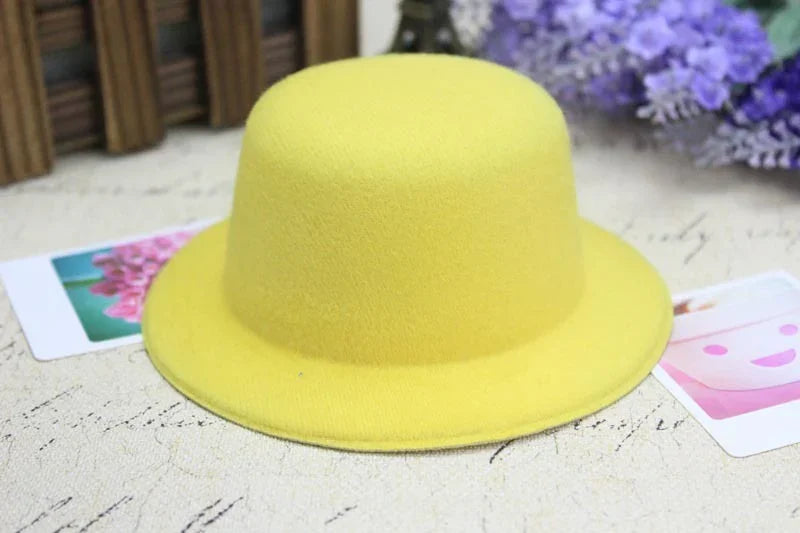 Yellow felt bowler hat on vintage paper with purple flowers and photo cards