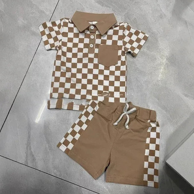 Kids checkered brown and white polo shirt with matching brown shorts featuring checkered side panels on tile floor
