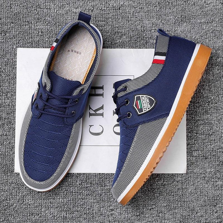 Blue and white casual sneakers with gum sole and fashion sport logo on gray carpet