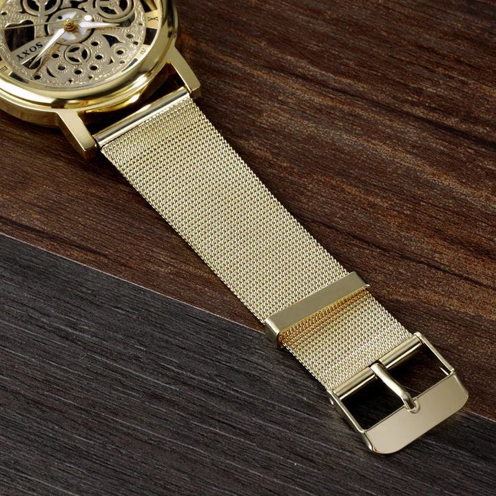 Close-up of gold mesh strap and skeleton dial watch on dark wooden surface