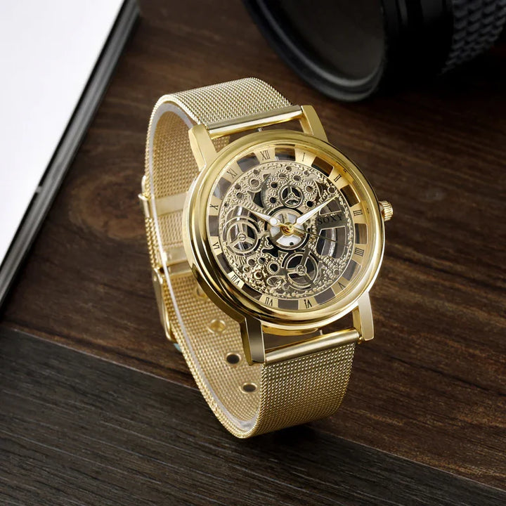 Luxury gold skeleton watch with mesh band resting on dark wood surface