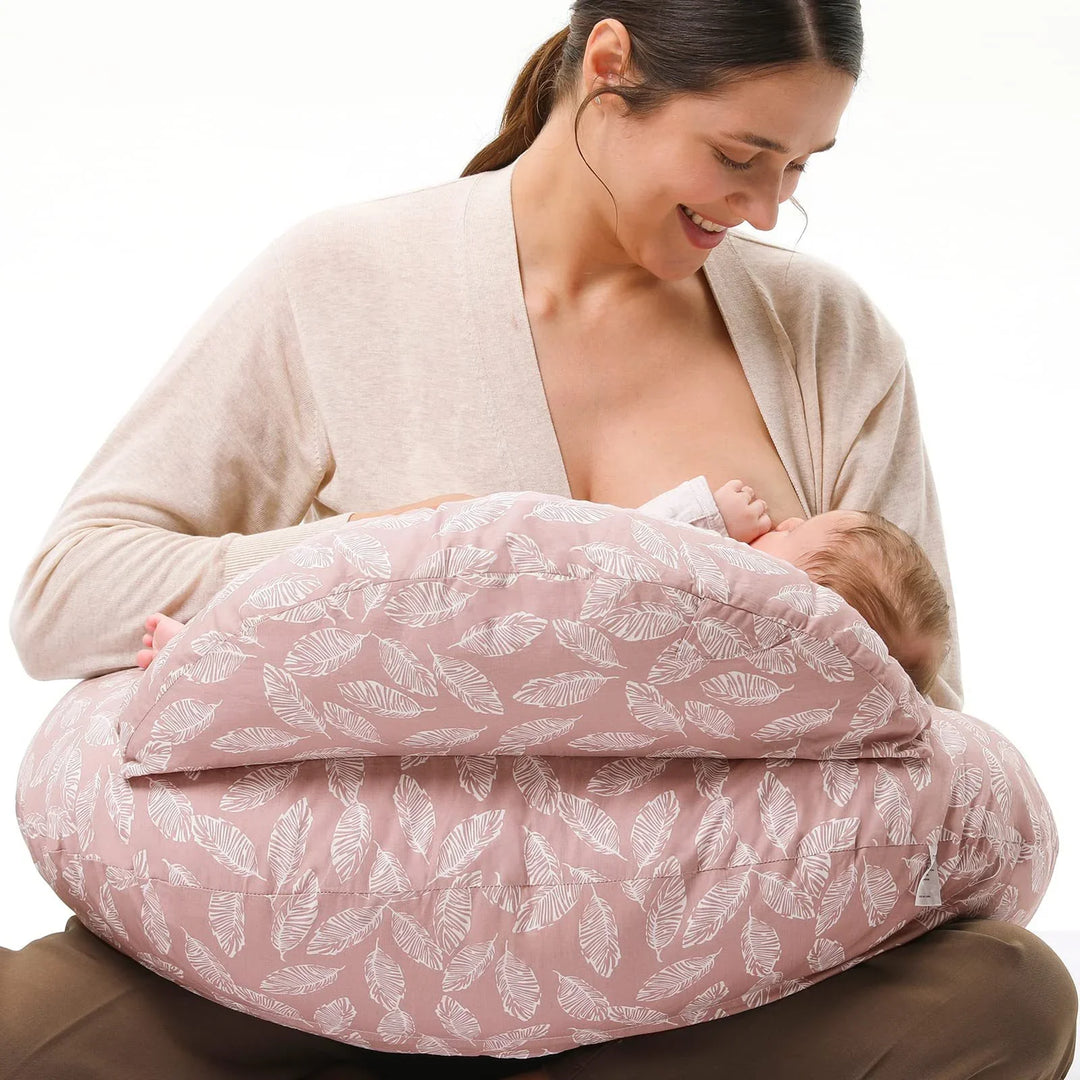 Mother breastfeeding baby using pink leaf-patterned nursing pillow