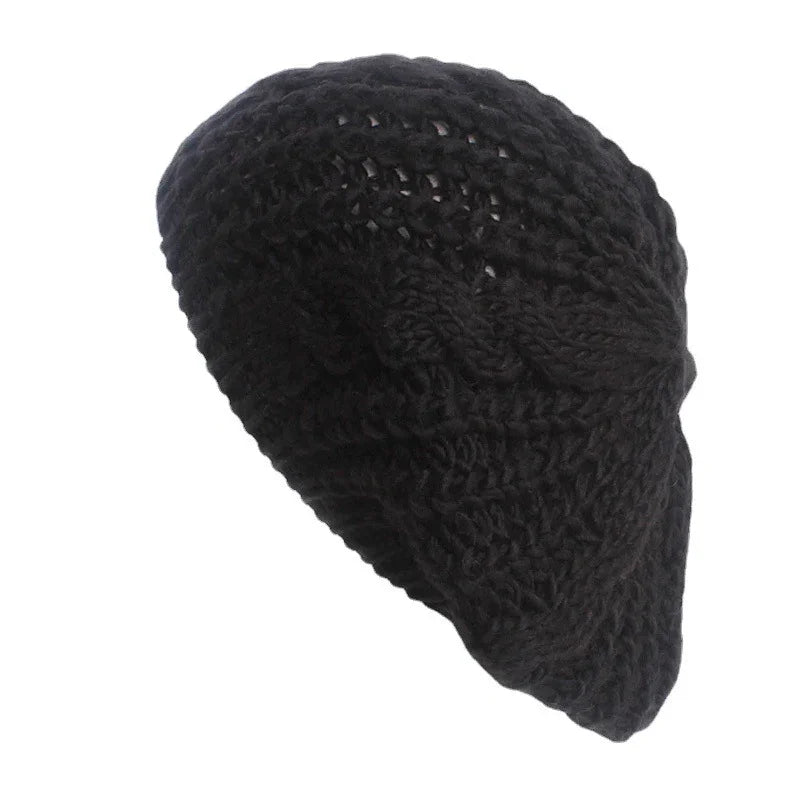 Black knitted crochet beret hat with textured pattern on white background