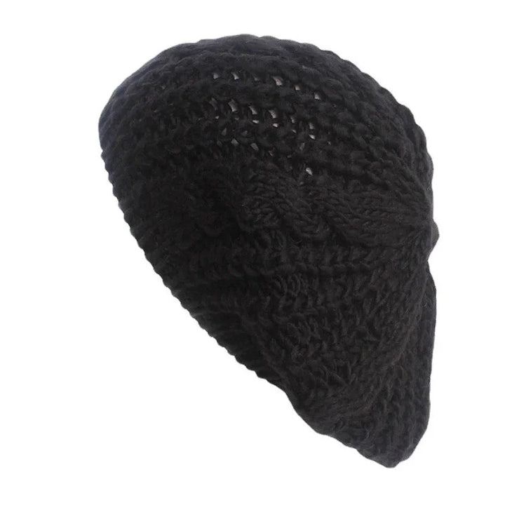 Black knitted crochet beret hat with textured pattern on white background