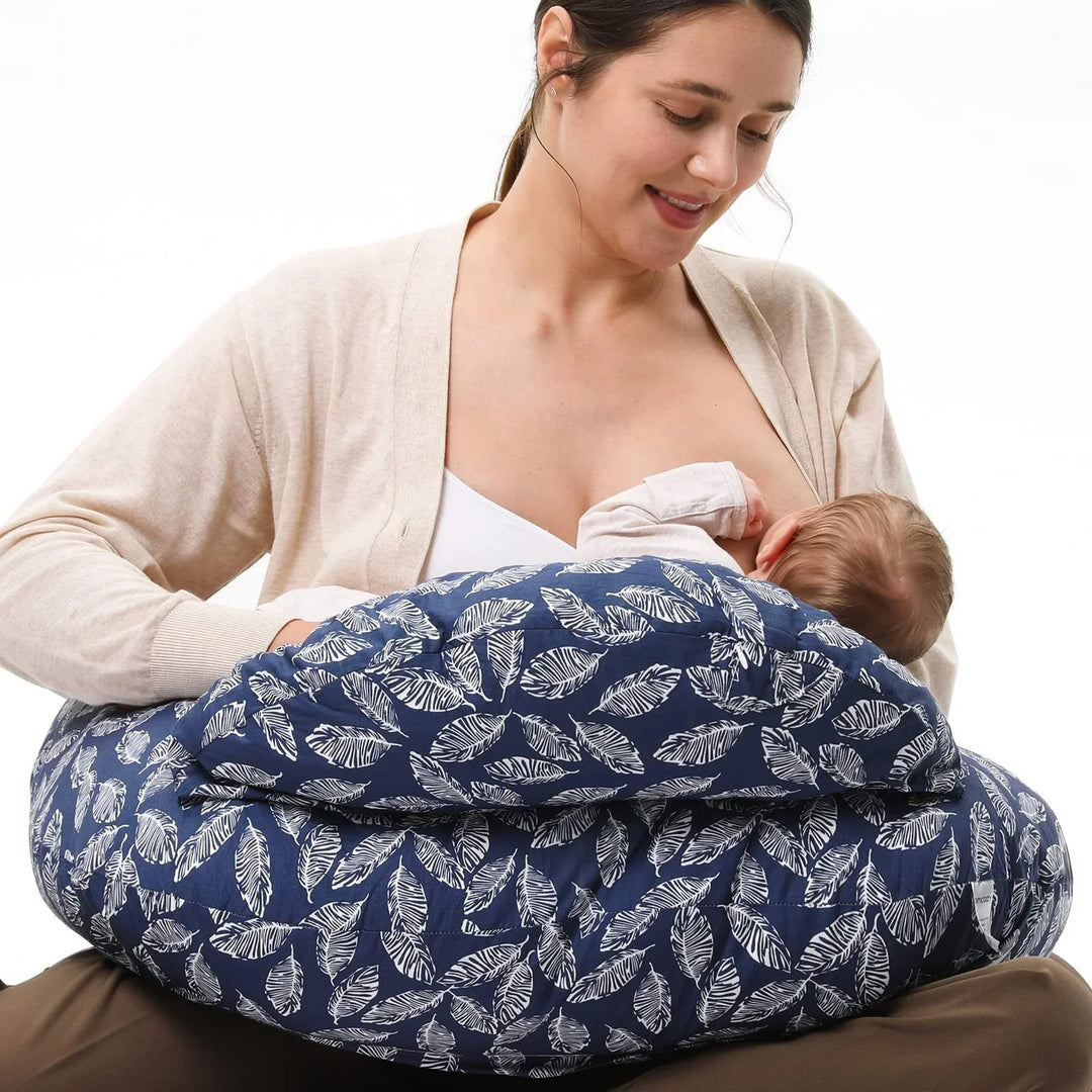 Mother breastfeeding baby using a navy blue pillow with white leaf pattern