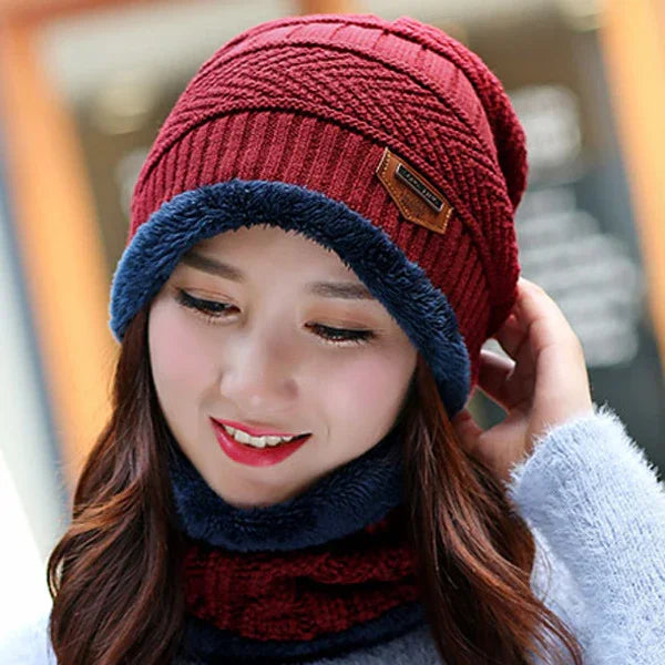 Young woman wearing a red knit beanie with blue faux fur lining and a matching neck warmer
